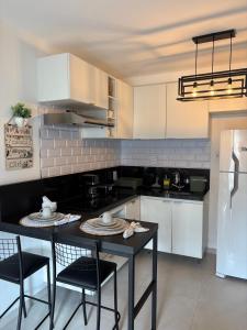 a kitchen with a table and chairs and a refrigerator at Studio completo com charme em ótima localização! in Juiz de Fora