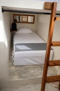 two bunk beds in a small room with a ladder at Frequency Hostel beachfront in El Cuyo