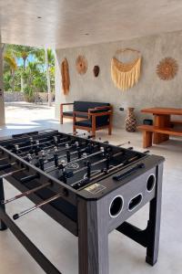 a large ping pong table in a room at Frequency Hostel beachfront in El Cuyo