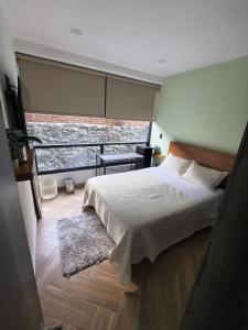 a bedroom with a bed and a large window at Downtown Historic Area Modern and Comfortable in Puebla