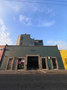 a green building with a door in front of it at Downtown Historic Area Modern and Comfortable in Puebla