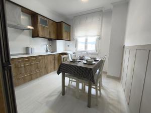 a kitchen with a table and chairs and a kitchen with a window at Curros in Ponte Do Porto