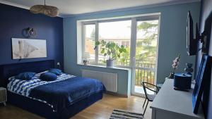 a blue bedroom with a bed and a window at W Ustce Lipa in Ustka