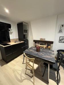 a kitchen with a table with chairs and a counter at La Villa Louana 4 Appartement neuf et moderne tout confort in Aubusson