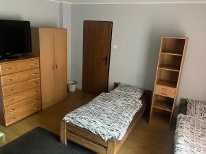 a room with a bed and a dresser and a tv at Noclegi Ściegiennego in Sosnowiec +9 photos