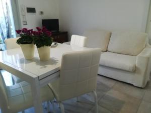 a living room with a white table with flowers on it at Nicla 3 in Fiorino