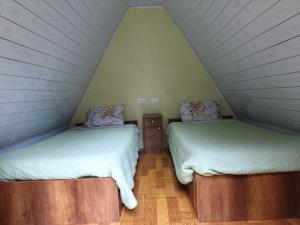 two beds in a room with a attic at Hay & Mountain Huts in Colcapampa