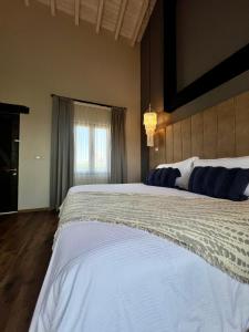 ein großes weißes Bett in einem Schlafzimmer mit Fenster in der Unterkunft Suites Campestres Montebello in Bernal