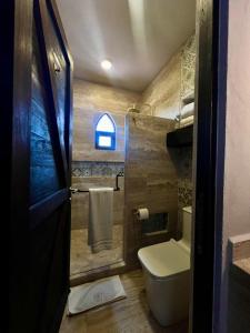 ein kleines Badezimmer mit Toilette und Fenster in der Unterkunft Suites Campestres Montebello in Bernal