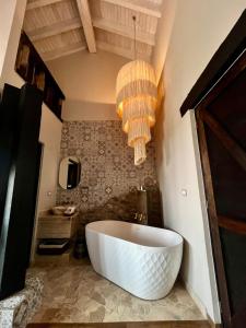 eine große weiße Badewanne in einem Badezimmer mit Kronleuchter in der Unterkunft Suites Campestres Montebello in Bernal + 200 Fotos