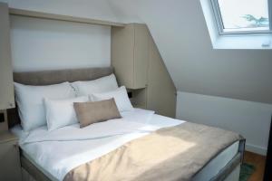 a bed with white sheets and pillows in a room at Giorgio Luxury Suites in Belgrade