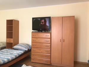 a bedroom with a bed and a television on a dresser at Noclegi Ściegiennego in Sosnowiec
