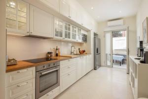 a kitchen with white cabinets and a counter top at New Luxury Villa Korcula Timeless with private pool, Free Parking, Seafront, for 6 persons in Korčula