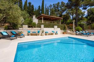 a swimming pool with chairs and a gazebo at New Luxury Villa Korcula Timeless with private pool, Free Parking, Seafront, for 6 persons in Korčula