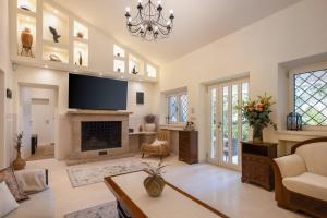 a living room with a fireplace and a flat screen tv at New Luxury Villa Korcula Timeless with private pool, Free Parking, Seafront, for 6 persons in Korčula