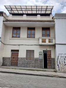 a white house with graffiti on the side of it at Albergue Happy Backpacker in Cuenca