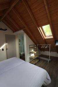 ein Schlafzimmer mit einem weißen Bett und einem Dachfenster in der Unterkunft Bed & Breakfast Zeeland in Renesse + 49 Fotos