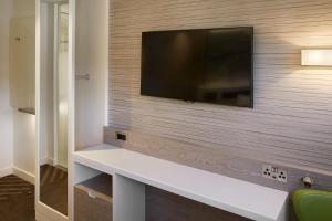 a living room with a television on a wall at hub London - Marylebone in London