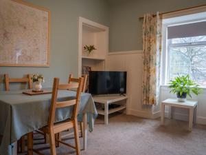 a living room with a table and a television at The Bothy in Blairgowrie
