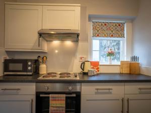 a kitchen with a stove top oven next to a window at The Bothy in Blairgowrie