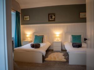 a bedroom with two beds with green pillows at The Bothy in Blairgowrie