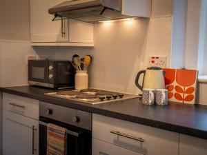 a kitchen with a stove and a microwave at The Bothy in Blairgowrie +20 photos