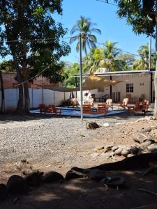 a house with chairs and umbrellas on a beach at Sunzal Bungalow Aloha in El Sunzal
