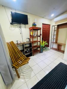 a living room with a bench and a flat screen tv at Sunzal Bungalow Aloha in El Sunzal