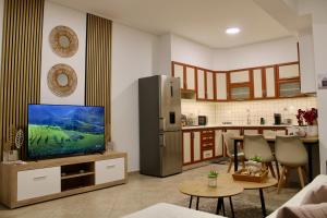 a living room with a tv and a kitchen at Home Irianna in Marathon