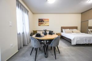 a bedroom with a bed and a table and chairs at Antheon Suites Volos in Volos +99 photos