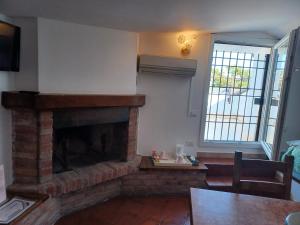 a living room with a brick fireplace and a table at Hotel Villa Pagoda in Sirmione
