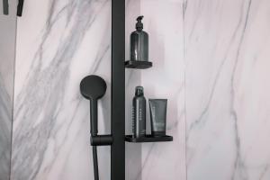 a black wall mounted shelf with two bottles on it at Kitz Alpine Apartments - City Center in Kitzbühel