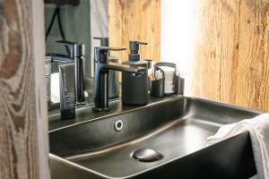 a kitchen sink with many soap dispensers on it at Kitz Alpine Apartments - City Center in Kitzbühel