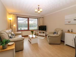 a living room with two couches and a tv at 48 Edenbank Road in Cupar