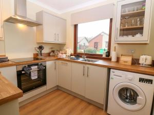 a kitchen with a sink and a washing machine at 48 Edenbank Road in Cupar