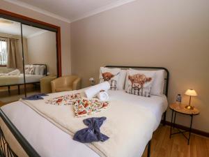 a bedroom with a bed with towels and pillows at 48 Edenbank Road in Cupar