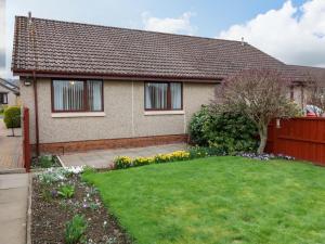 a house with a green yard with flowers at 48 Edenbank Road in Cupar