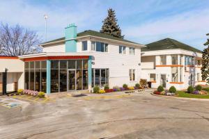a large white building with a parking lot at Howard Johnson by Wyndham Brampton in Brampton