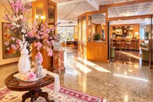 a lobby with a table with flowers on it at Greif Hotel & Spa in Trieste