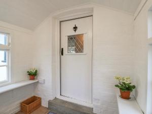 a white door in a white room with flowers at The Old Smithy in Cambridge +32 photos
