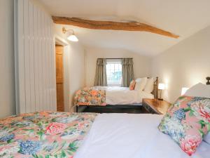 a bedroom with two beds and a window at The Old Smithy in Cambridge