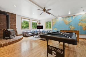 a living room with a pool table and a map at Modern Cottage Laurentians Private Pool & Nature in Brownsburg