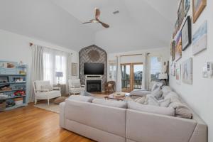 a living room with a couch and a tv at 5468 - Mermaids' Lagoon in Nags Head