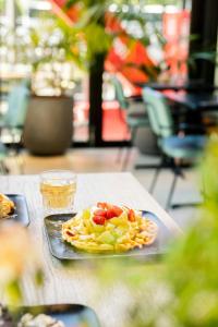 Ein Teller mit Essen und ein Getränk stehen auf einem Tisch. in der Unterkunft The Social Hub Eindhoven in Eindhoven
