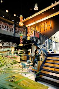 a lobby with a staircase and tables and chairs at The Social Hub Eindhoven in Eindhoven