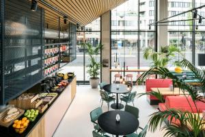 ein Café mit Tischen und Stühlen in einem Gebäude in der Unterkunft The Social Hub Eindhoven in Eindhoven