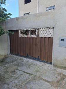 a brown garage door with a fence on a building at Confort Suite 01 in Contagem