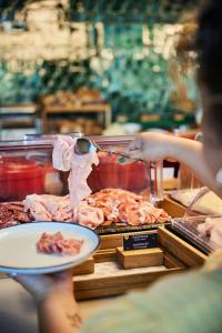 a person is holding a plate of food on a table at The Social Hub Berlin Alexanderplatz in Berlin