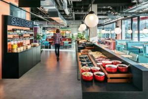 a person walking down a aisle in a store at The Social Hub Berlin Alexanderplatz in Berlin