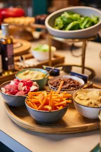 a buffet with bowls of food on a table at The Social Hub Berlin Alexanderplatz in Berlin +58 photos